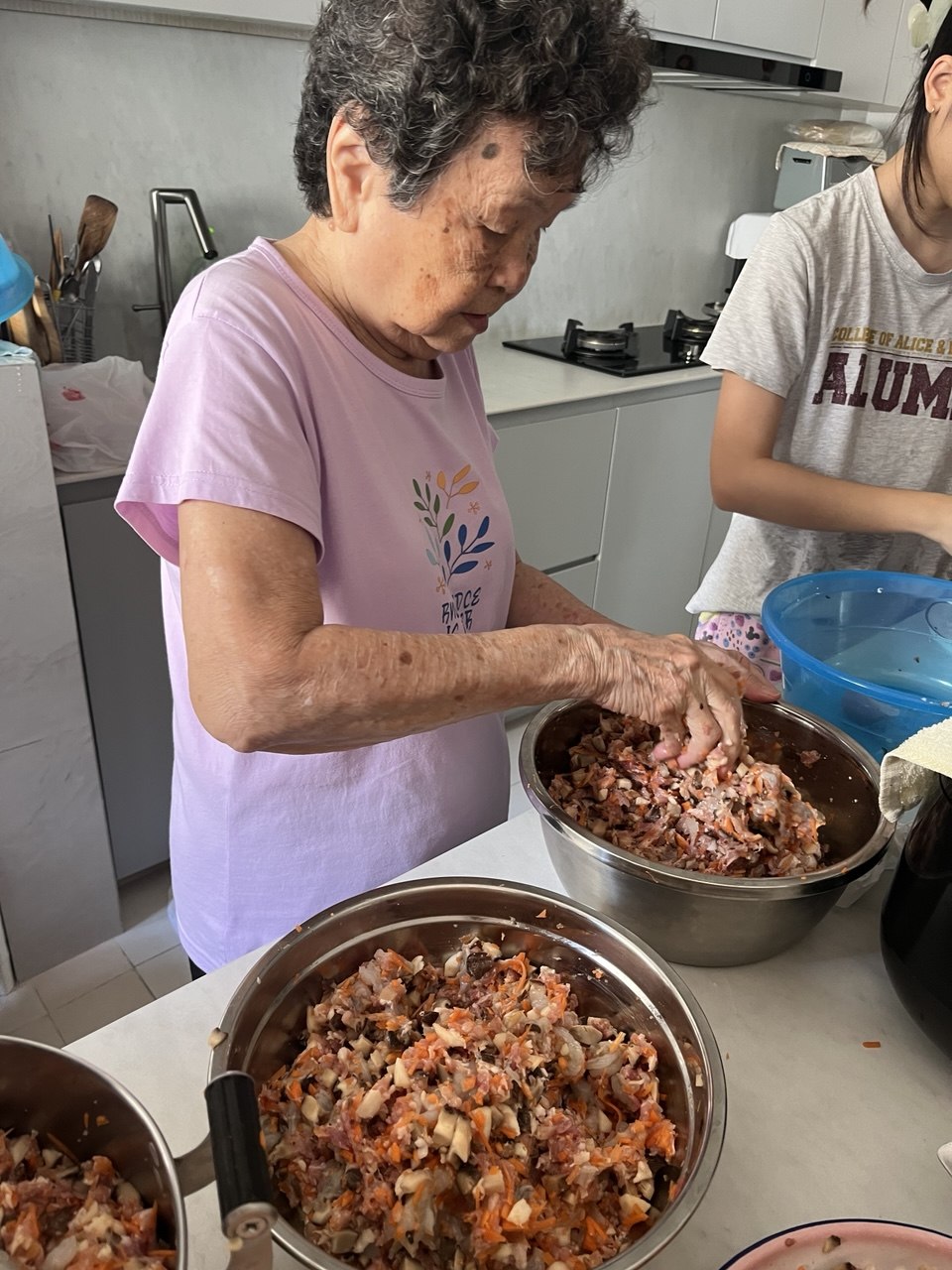 Ah Ma mixing the ngoh hiang filling by hand in her kitchen.